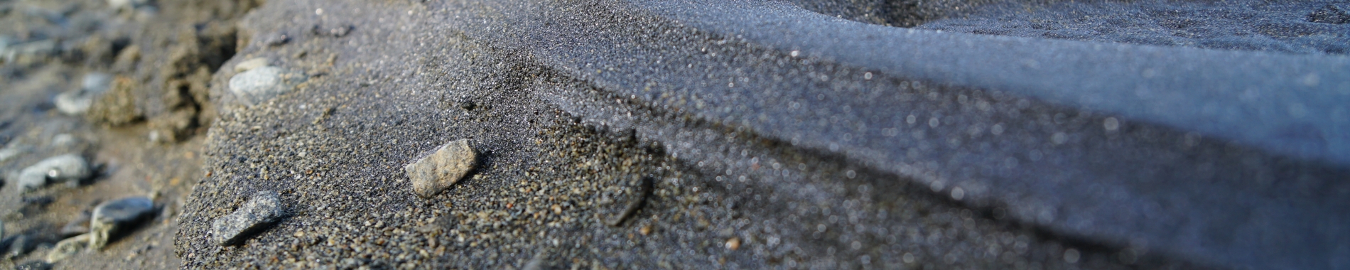 close up of dark sand small rocks